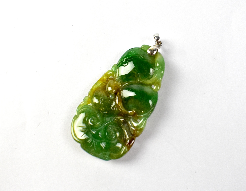 A spinach and multicoloured green jade pendant of abstract form, length 4.5cm.