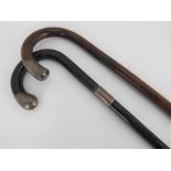 Two walking canes both with silver tips, one black lacquered with silver presentation collar,