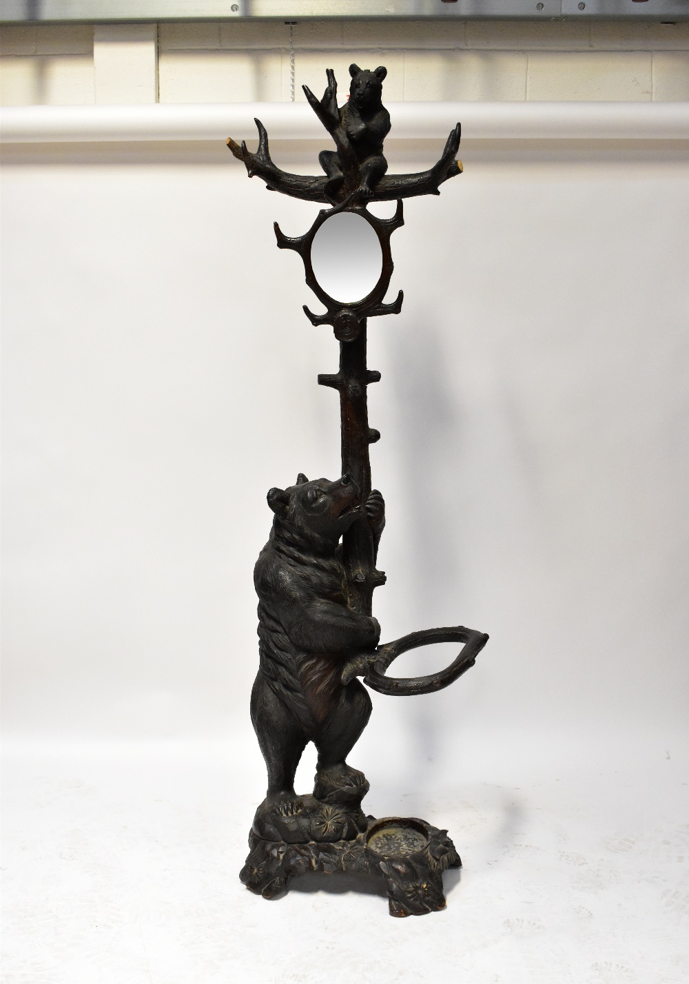 A 19th century Black Forest carved stick stand in the form of a tree with a bear raised on back