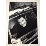 JOHN TRAVOLTA; a black and white photograph bearing his signature.