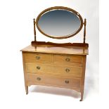 An Edwardian mahogany dressing chest with oval bevelled mirror above two short and two long drawers,
