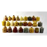 Twenty-five ceramic honey pots, some in the form of beehives, some with floral decoration,