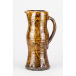 CLIVE BOWEN (born 1943); a large slipware jug covered in treacle glaze with trailed and impressed