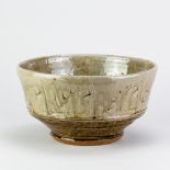 MIKE DODD (born 1943); a large stoneware bowl covered in green ash glaze with incised decoration,