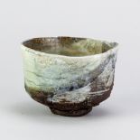 MARGARET CURTIS (born 1955); a stoneware chawan with textured surface partially covered in celadon