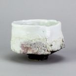 EDDIE CURTIS (born 1953); a stoneware chawan with textured surface covered in shino glaze, impressed