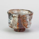 CHARLES BOUND (born 1939); a wood fired stoneware chawan covered in shino and tenmoku glaze,