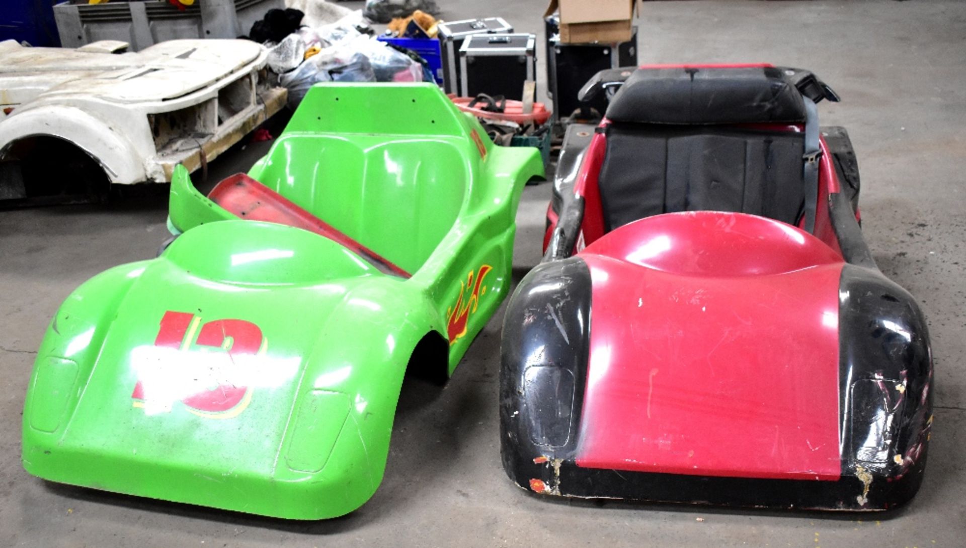 A pair of fibreglass dodgem car shells, one green, with number '13',