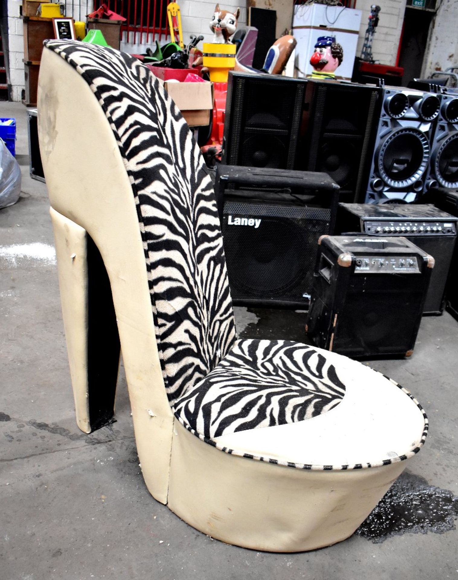 A chair in the form of a stiletto, upholstered in beige leatherette and faux zebra skin (af).