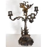 ELKINGTON & CO; a silver plated three branch candelabrum with cast decoration depicting stags in a