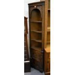 A reproduction oak freestanding corner cupboard of small proportions,