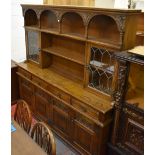 A reproduction oak side cabinet, the upper section with shelves flanked by twin leaded glazed doors,