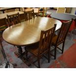 An oval oak dining table with integral leaf,