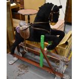 A contemporary treadle based rocking horse modelled as if jumping a show jumping fence.