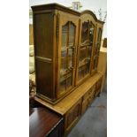 A reproduction oak dresser with three glazed doors above a base of three drawers and twin cupboard