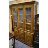 A Continental oak and elm bookcase with glazed upper section above cupboard doors, height 190cm,