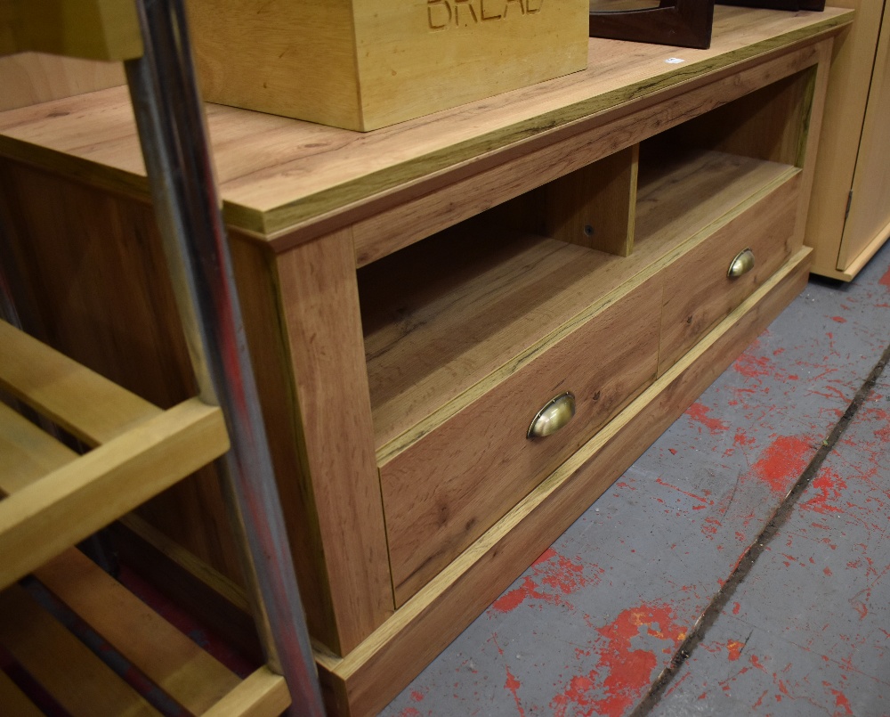 A contemporary low side table with open aperture above two base drawers, length 122cm.