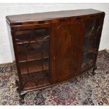 An early 20th century mahogany bowfronted display cabinet with central panelled door flanked by