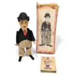 SCHUCO; a tinplate clockwork figure of Charlie Chaplin with box, with felt clothes, height 16cm (2).