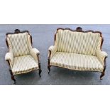 An Edwardian carved walnut wing back two seater sofa and matching armchair upholstered in a