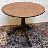 A George III mahogany circular tilt-top table on turned column and tripod supports, diameter 84cm.