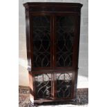A George III mahogany freestanding corner cabinet, with moulded cornice above two pairs of