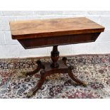 An early 19th century mahogany fold over swivel-top tea table on carved baluster support,