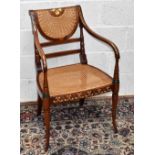 A Regency style painted wood carver chair, with caned back and seat, on turned faux bamboo legs.