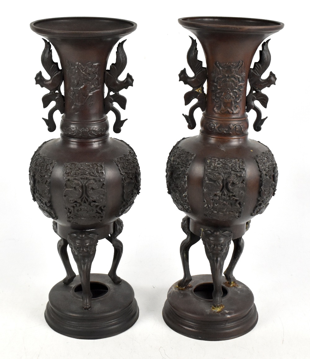 A pair of Japanese Meiji period bronze vases with moulded twin handles, height 43cm (2).