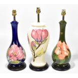 MOORCROFT; three ceramic table lamps comprising two baluster shaped examples decorated in the '