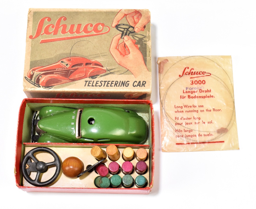 SCHUCO; a boxed tinplate clockwork telesteering car with ball pegs, ball, steering wheel, key and