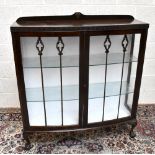 An early 20th century mahogany bowfronted twin door display cabinet, on ball and claw feet, width