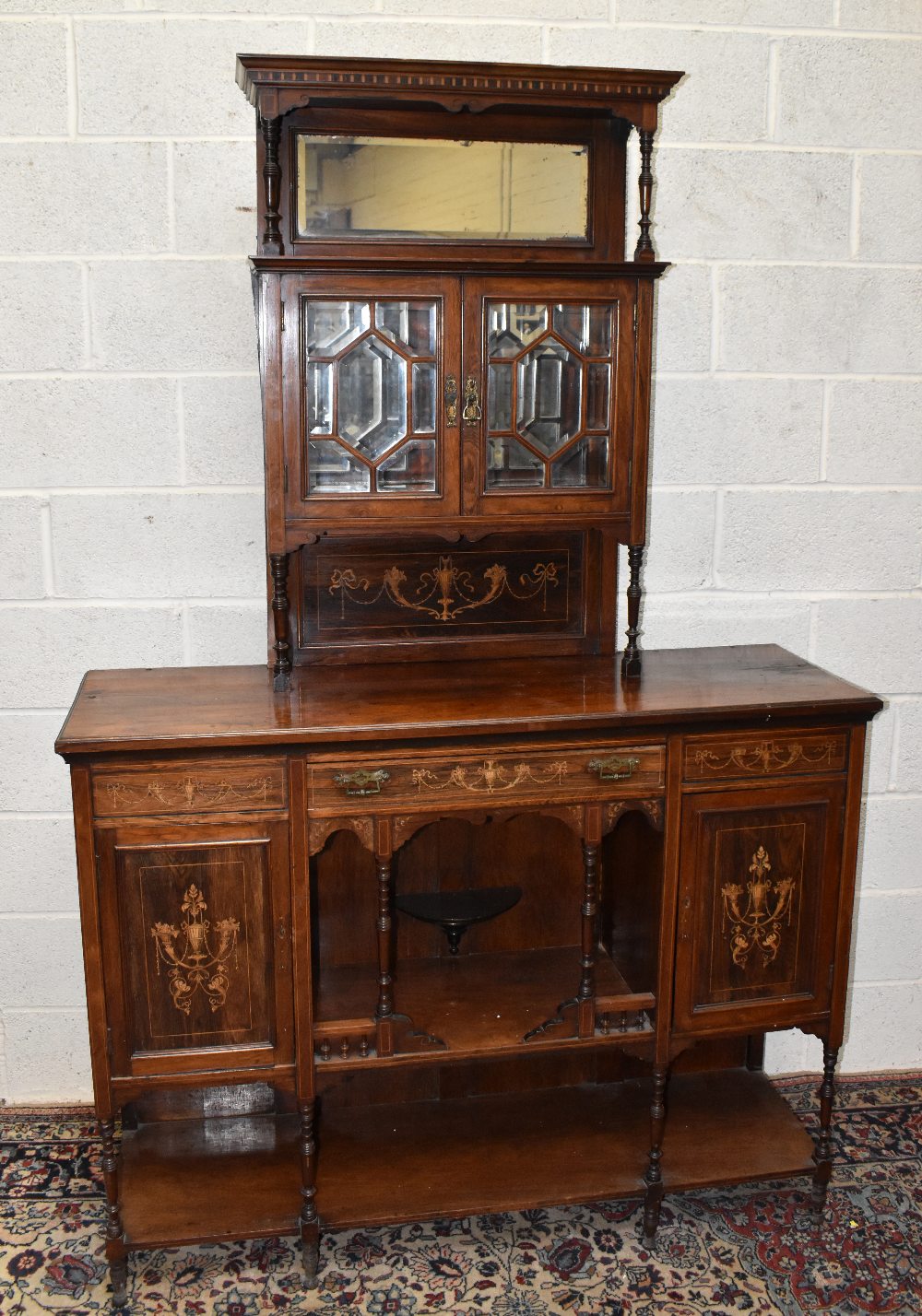 An Edwardian rosewood chiffonier, with reduced top above a drawer, two cupboard doors and undertier,