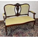 An Edwardian parlour settee with central carved stretcher with moulded floral decoration and moulded