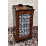 A late Victorian rosewood cabinet with pierced galleried top above a single glazed door enclosing