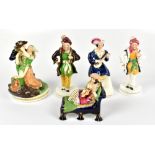 Five 19th century ceramic figures including a Staffordshire example of a Scot seated playing a lute,