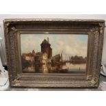 Continental village scene. signed. Oil on canvas in an ornate gilt frame. 80 x 50cm Frame 115 x