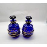 A pair of Victorian Bristol Blue glass lidded jars with gilt handpainted design.