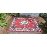 Large wool rug in red cream and blue tones. 20thC Very good condition.