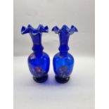 A pair of Victorian hand painted Bristol blue glass vases with fluted rims.