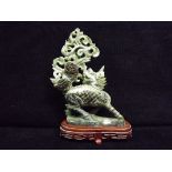 Chinese Jade carving on wooden stand. Qilin hooved mythical beast breathing smoke and fire, head