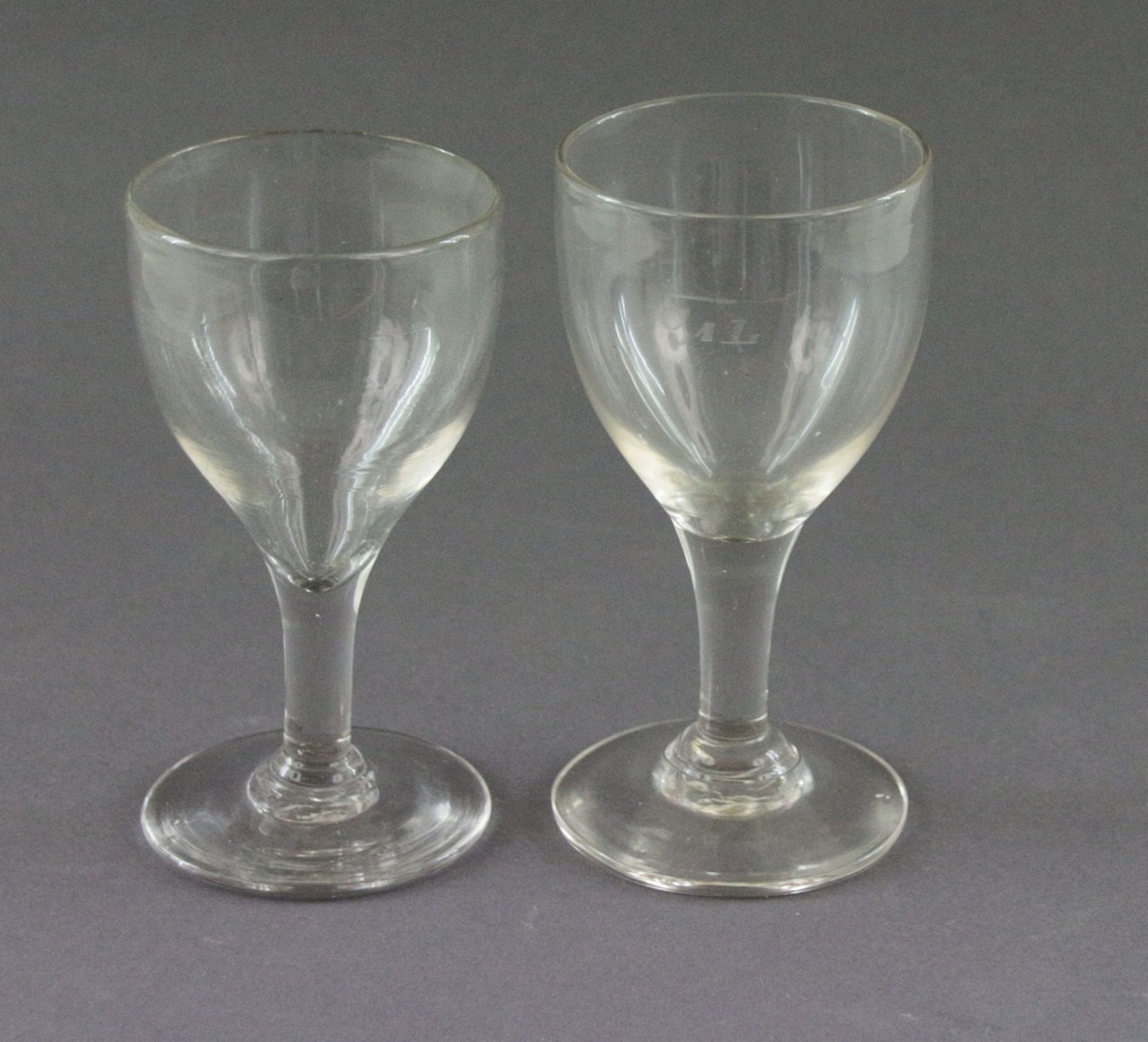 2 Weingläser, um 1900 , Farbloses Glas. Auf Scheibenfuß eiförmiger Glaskorpus. 1 Glas mit