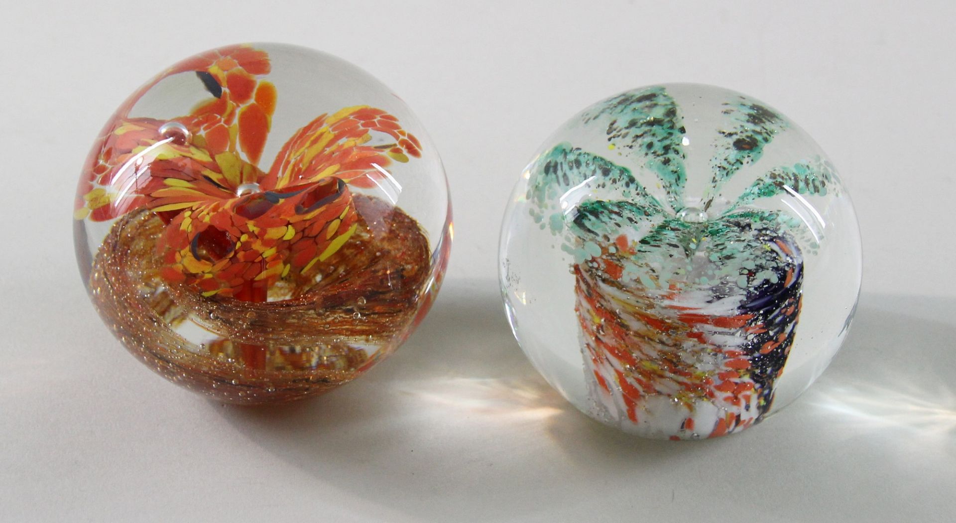 2 Paperweights, "Blüten", 20. Jhd. Kugelige Form, Klarglas, zentrale vielblättrige Blüte in Grün