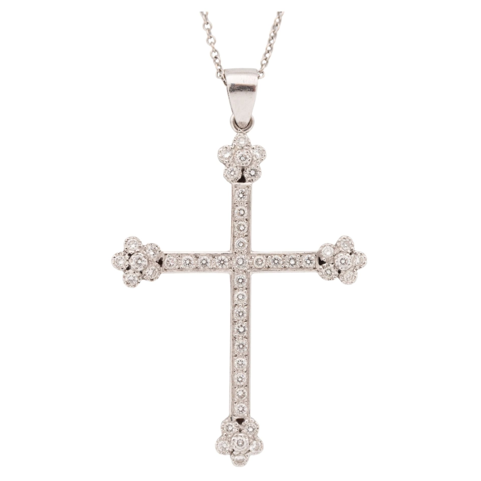 Colgante diseño cruz en oro blanco con diamantes.