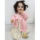 Porcelain headed doll made in German No 57 to rear of skull - 24" long with brown eyes