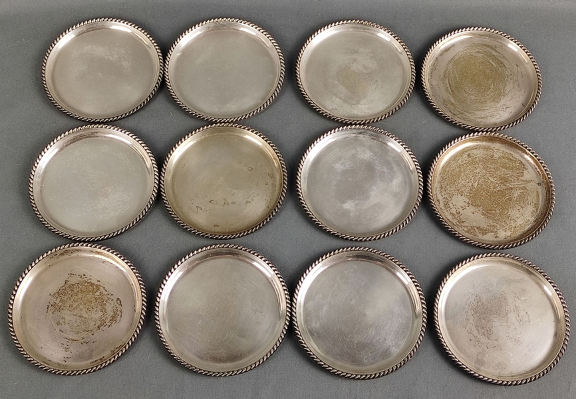 12 Untersetzer mit Kordelreliefrand, Sterlingsilber, 387g, Durchmesser 9cm, Altersspuren