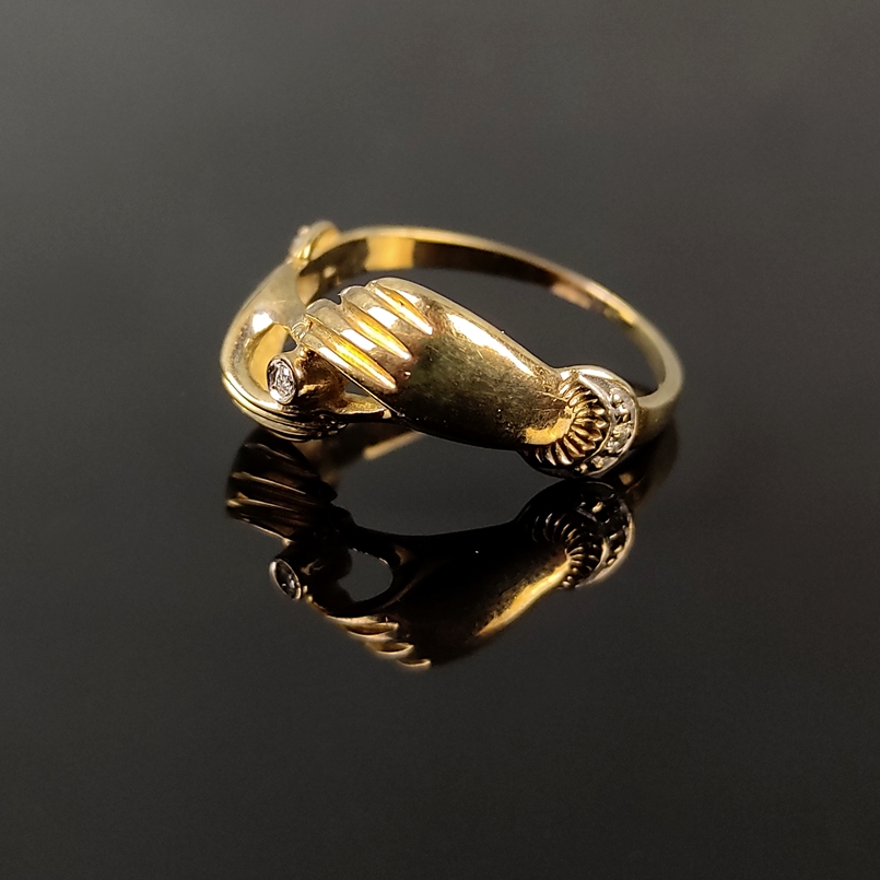 Two-hands-ring, centered small diamond, 333/8K yellow gold, 2.23g, made of two hands holding a smal