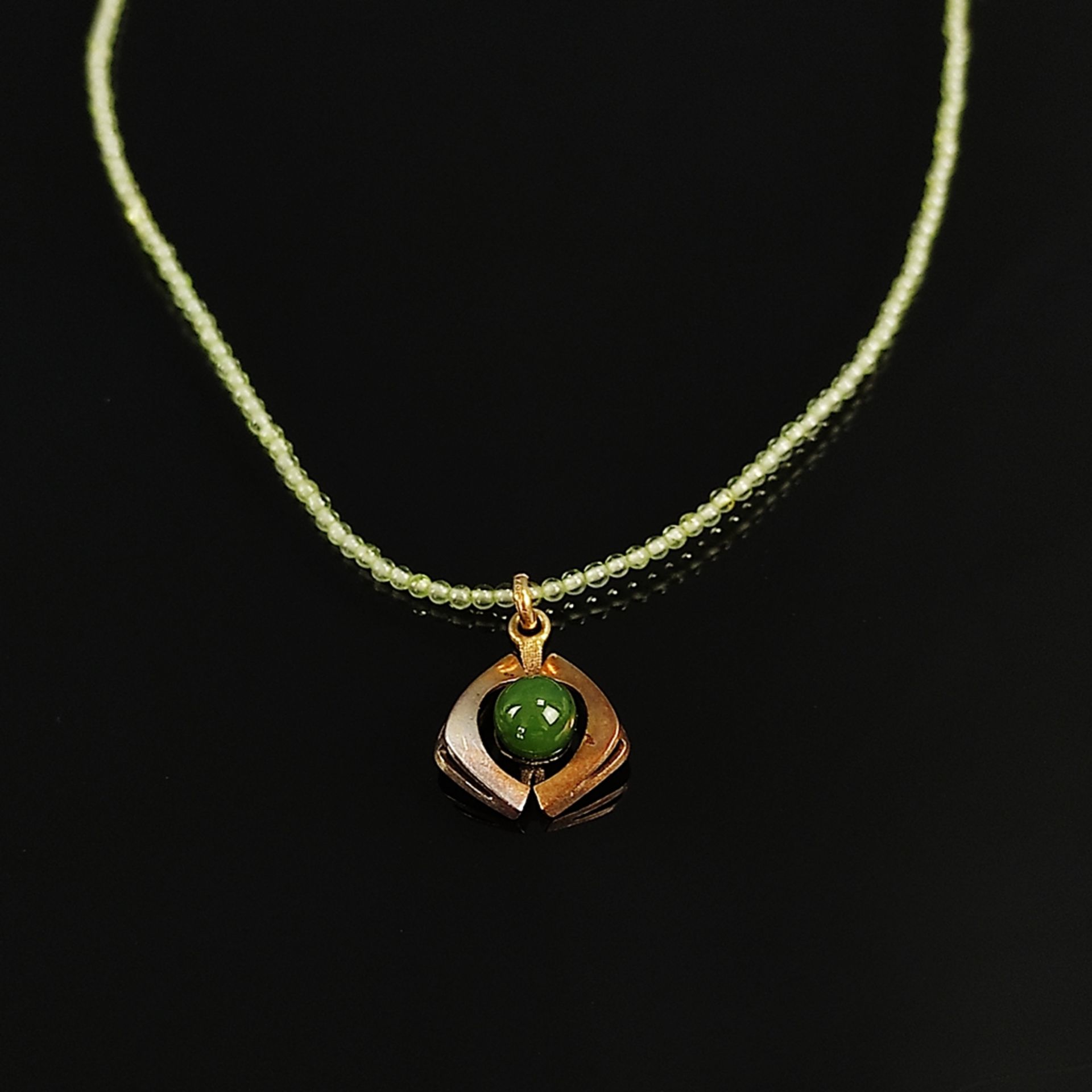 Jade pendant on peridot chain, 333/8K yellow gold, total weight 5,10g, pendant set with a fine poli