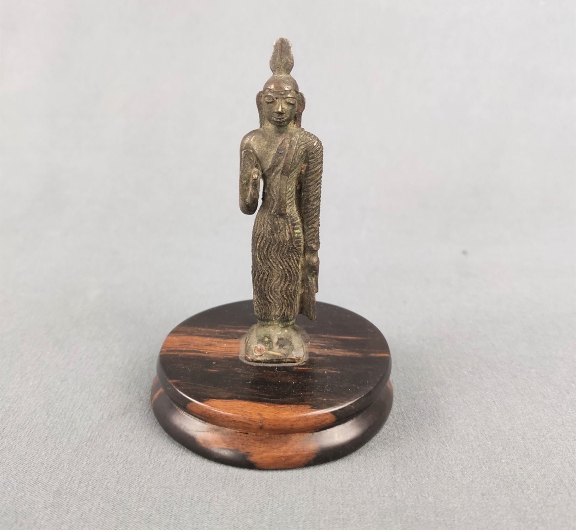 Small Buddha figure, probably Ceylon, probably 17th century, bronze on small round base, height 10.