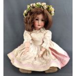 Puppe von "Kämmer und Reinhardt" mit Blumenkranz, grüne Glasaugen und schulterlange Perücke, in auf